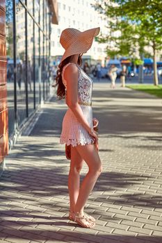 Sunny lifestyle, young stylish hipster woman walking on the street, wearing trendy outfit, straw hat, travel.