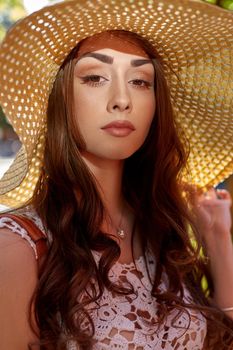 Sunny lifestyle fashion portrait of young stylish hipster woman walking on the street, wearing trendy outfit, straw hat, travel.