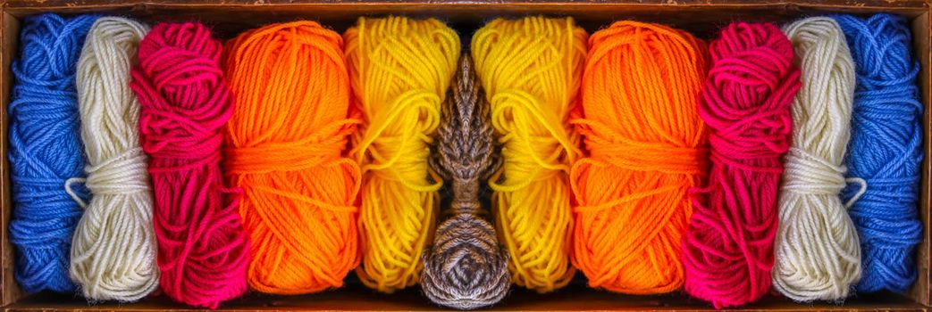 Colorful skeins of yarn in old wooden vintage box close up