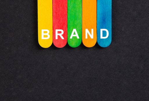 Business concept.Text BRAND writing on colored sticks on wooden background.