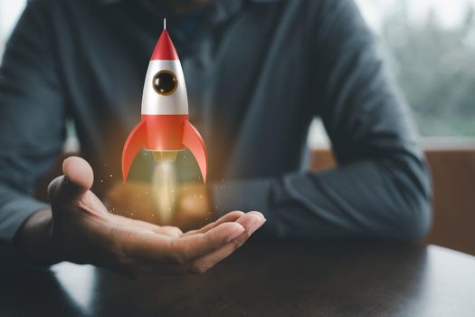 Business startup. Businessman holding rocket 3D icon on hand, rocket takes off launching and soar flying out, marketing on modern virtual interface, business digital innovation accelerate idea concept
