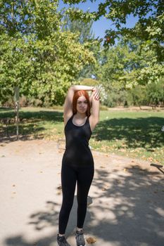 Young redhead athlete stretching in a park before running outdoors in summer, healthy lifestyle concept. stock photography