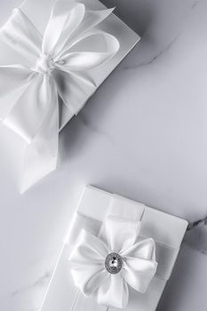 Romantic celebration, bridal decor and holiday present concept - Luxury wedding gifts with silk bow and ribbons on marble background