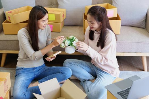 Portrait of Starting small businesses, two Asian woman check online orders Selling products working with boxs freelance work at home office, sme business concepts