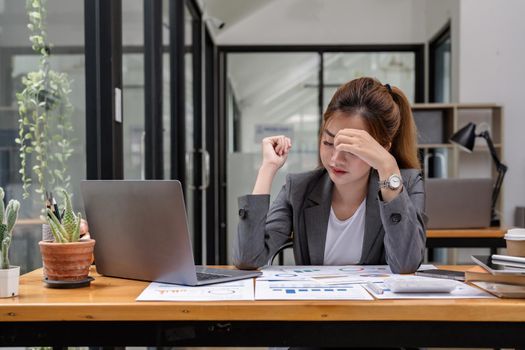 Stressed business woman working from home on laptop looking worried, tired and overwhelmed