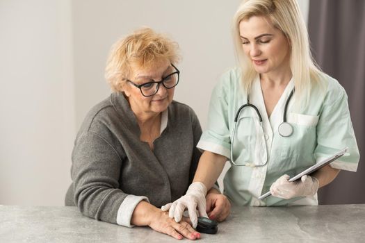 doctor talk with old female patient about disease symptom, doctor use fingertip pulse oximeter with old patient, elderly health check up and health screening, medical technology.