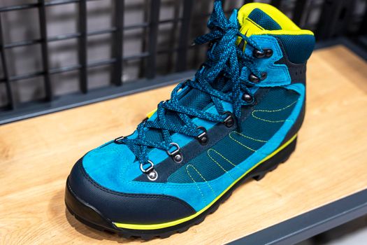 New modern turquoise sports demi-season boots with lacing close-up on a wooden surface