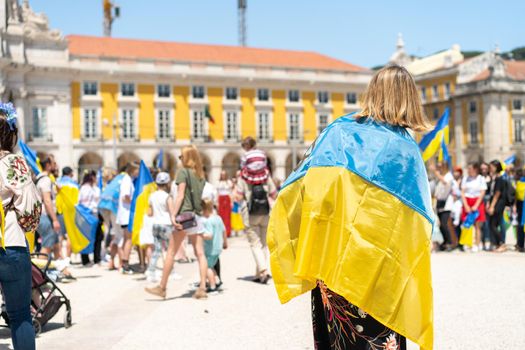 Portugal, Lisbon April 2022: The demonstration on Commerce Square in support of Ukraine and against the Russian aggression. Protesters against Russia's war Many people with Ukrainian flags. Crowd