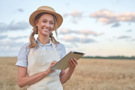 Woman farmer straw hat smart farming standing farmland smiling using digital tablet Female agronomist specialist research monitoring analysis data agribusiness Caucasian worker agricultural field