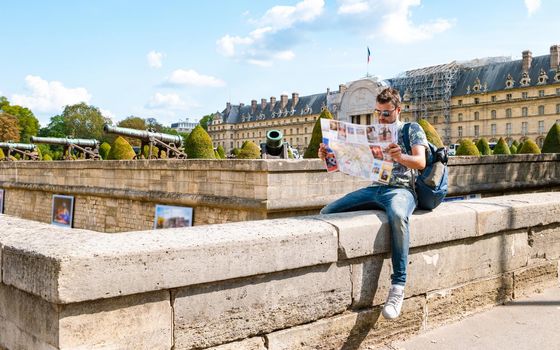 Young men with a tourist map in hand in the city of Paris France. Man tourist in Paris