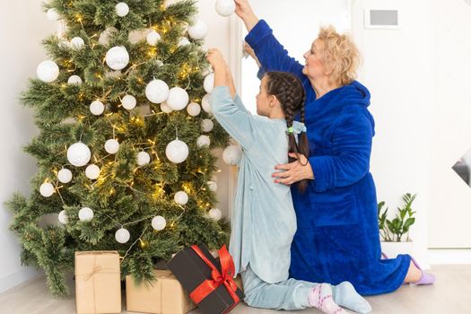 Cute little girl granddaughter family celebrating Christmas New Years Eve at home. Winter holiday concept.