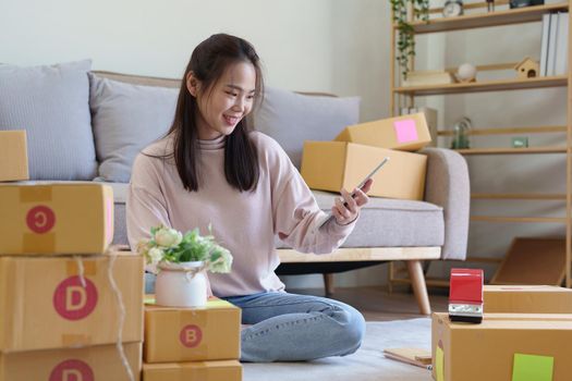 Portrait of Starting small businesses, Asian woman check online orders Selling products working with boxs freelance work at home office, sme business concepts