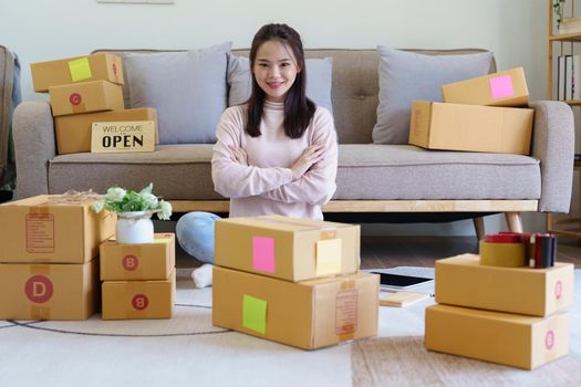 Portrait of Starting small businesses, Asian woman check online orders Selling products working with boxs freelance work at home office, sme business concepts