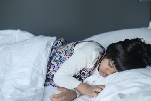 4 year old child girl sleeping on bed .