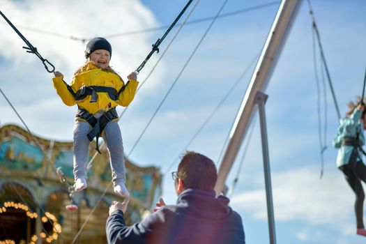 A smilling girl jumping on a trampoline with insurance.