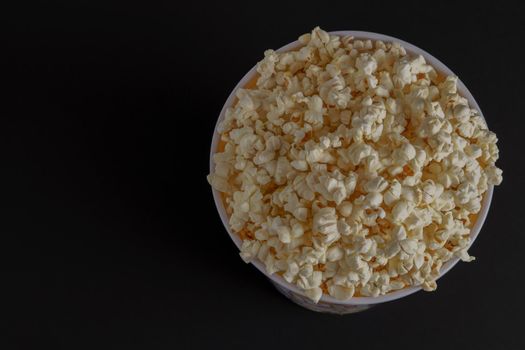 close-up of a popcorn container with colored letters on a black background