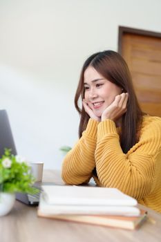 woman smiling happily while using computer at home.