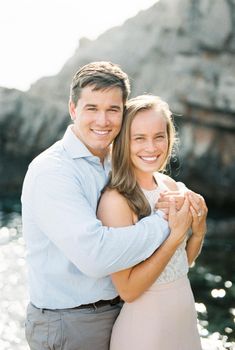 Smiling man hugs woman near the cliff. High quality photo