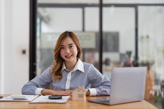 Real estate agent working with laptop at table in office