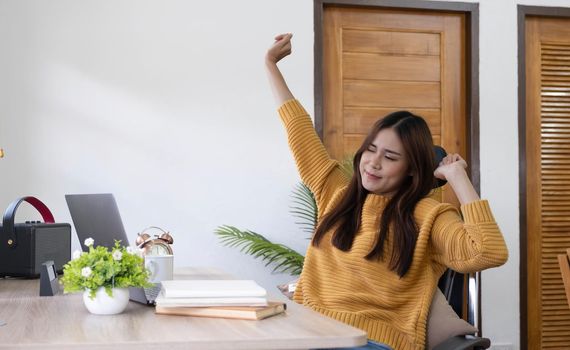 Happy young woman stretches her body after hard worling day..