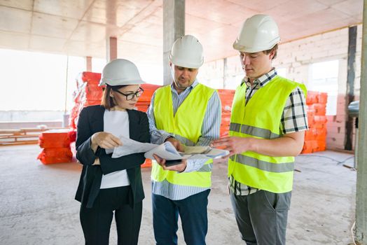 Group of business people at construction site. Builder, inspector, engineer, architect, customer, people working at building