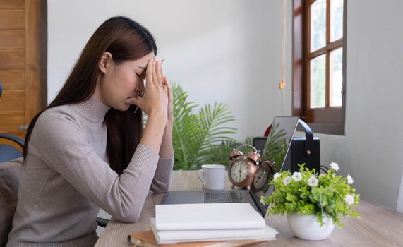 Asian young woman seriously working on computer laptop in house. She thinking find solution problem of work.