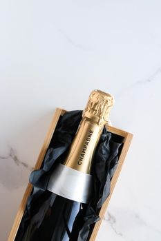 Wedding celebration, lifestyle and luxury present concept - A champagne bottle and a gift box on marble