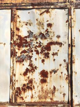 Corroded metal background. Rusted white painted metal wall. Rusty metal background with streaks of rust. Rust stains. The metal surface rusted spots. Rystycorrosion.