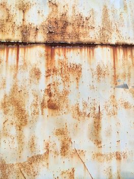 Corroded metal background. Rusted white painted metal wall. Rusty metal background with streaks of rust. Rust stains. The metal surface rusted spots. Rystycorrosion.