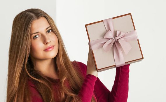 Holiday present for birthday, baby shower, wedding or luxury beauty box subscription delivery, happy woman holding a wrapped pink gift on white background