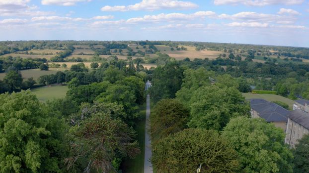 Aerial top down view from the drone onto the narrow passageway leading to a small chapel. Chapel located in a big green open area of fields near Rosary Manor, Mill Hill, North West London, London, UK.
