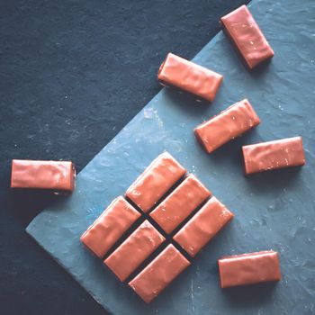 Dessert, confectionery and gluten-free organic food concept - Sweet swiss chocolate candies on a stone tabletop, flatlay