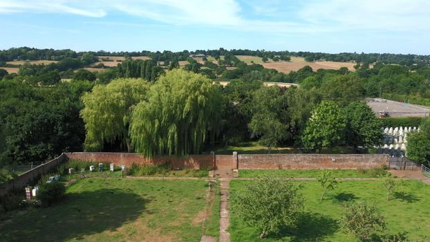 Aerial top down view from the drone onto the narrow passageway leading to a small chapel. Chapel located in a big green open area of fields near Rosary Manor, Mill Hill, North West London, London, UK.