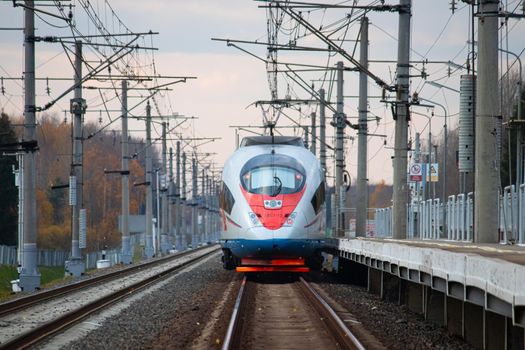 High - speed train sapsan in autumn . An article about high-speed trains. Train Moscow - Saint Petersburg. Lyuban, Russia, October 11, 2021