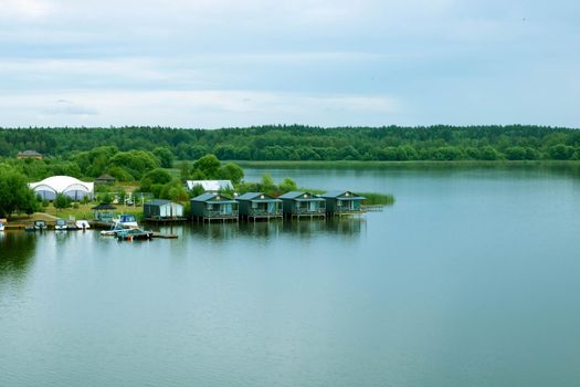 Small wooden houses on the river on a cloudy day.