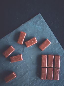 Dessert, confectionery and gluten-free organic food concept - Sweet swiss chocolate candies on a stone tabletop, flatlay