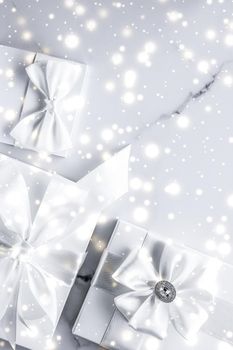 New Years Eve celebration, winter decoration and Valentines Day presents concept - Luxury holiday gifts with white silk bow and ribbons on marble background, Christmas time surprise