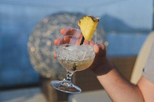 Hand holding a pina colada cocktail with ice