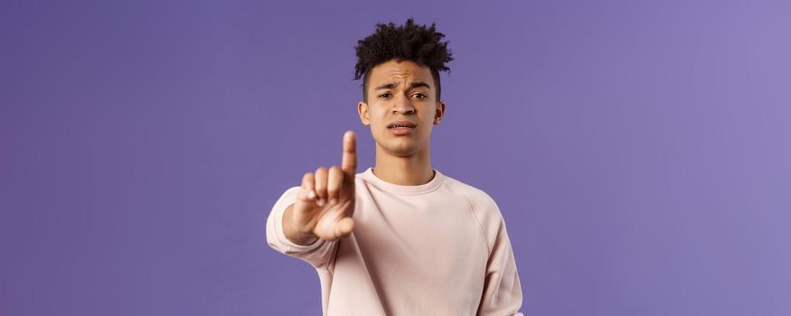 Close-up portrait of serious-looking hispanic man trying to prevent something bad, steping in for person being bullied, shaking index finger to scold wrong behavrious, forbid and prohibit something.