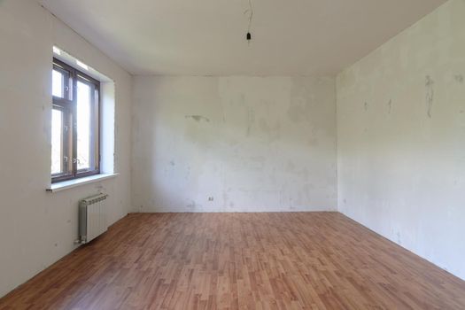 Interior of a small empty room with one window during renovation a