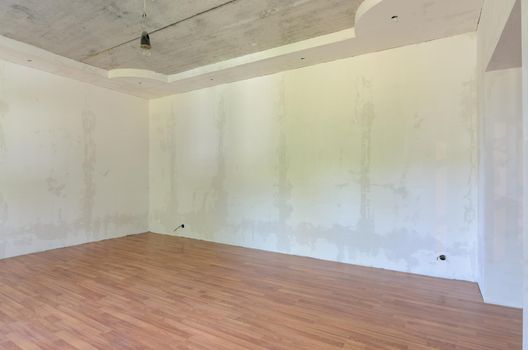 Interior of an empty room after renovation, gray walls, laminate flooring on the floor a