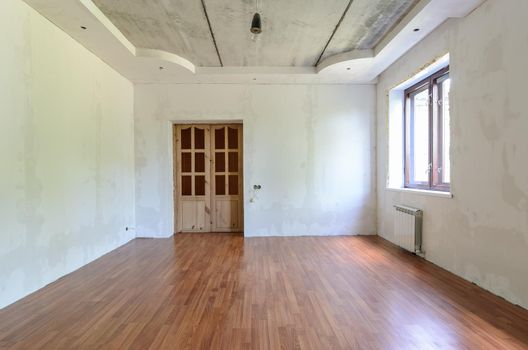 The interior of an empty room with a fine renovation, a laminate is laid on the floor a