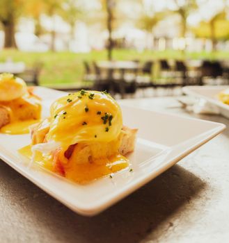 Restaurant service, food recipes and breakfast concept - Poached egg with salmon for brunch in a luxury restaurant