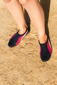 Swimming neoprene shoes in water on beach. 