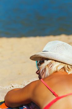 Attractive Young Woman Wearing Bathing Suit Lays On Sand Beach