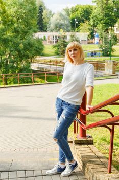Beautifyl young woman in casual style posing in park