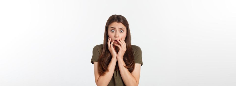 Close-up portrait of surprised beautiful girl holding her head in amazement and open-mouthed. Over white background.