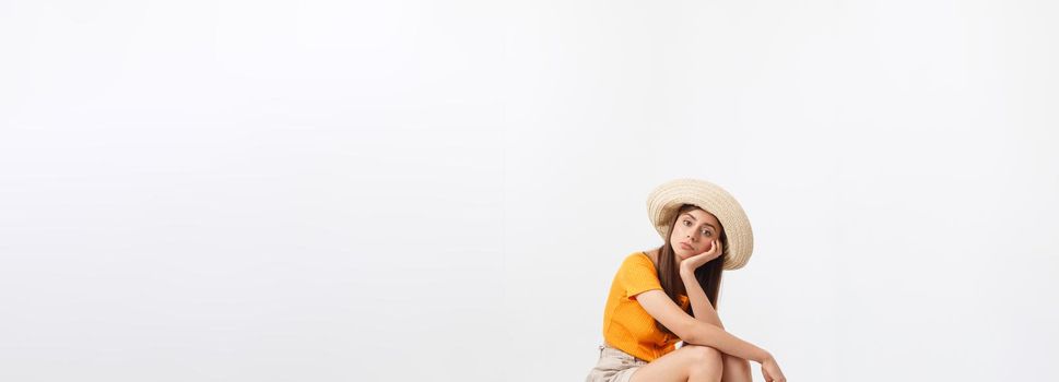 Lifestyle and travel Concept: Young beautiful caucasian woman is sitting on suitecase and waiting for her flight.Isolated over white background.