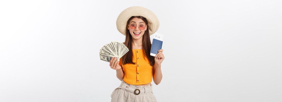 Portrait of cheerful, happy, laughing girl with hat on head, having money fan and passport with tickets in hands, isolated on white background.