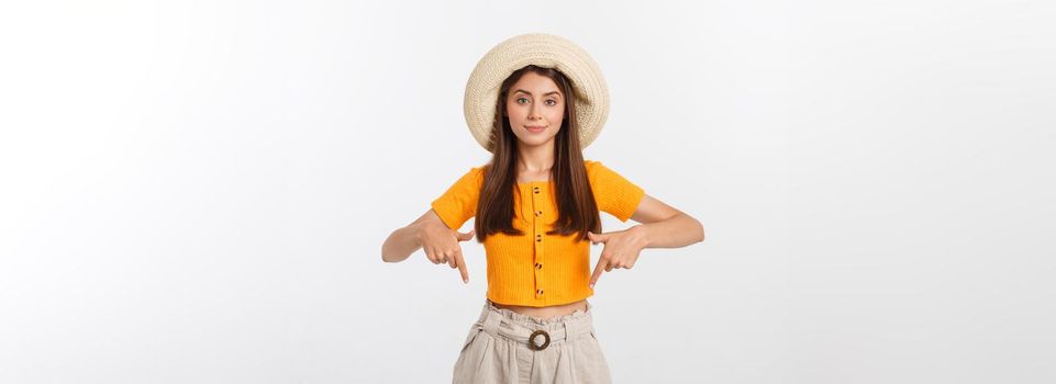 Teenager girl on summer vacation surprised and pointing finger on copy space over isolated white background